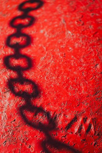 Тень от цепи на красной бочке