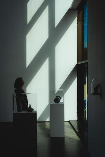 Свет из окна падает на силуэт женщины