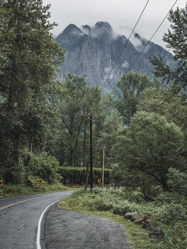 Изгиб дороги и гора в тумане вдалеке