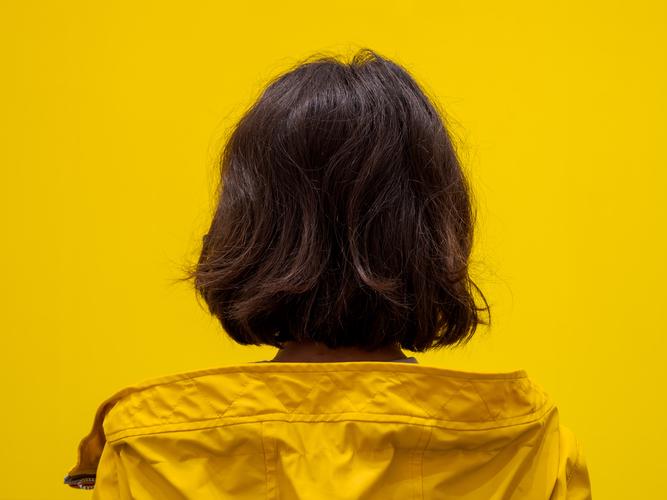 Девушка в желтой куртке на желтом фоне