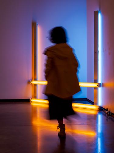 Силуэт в неоновом свете инсталляции в музее