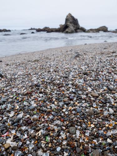 View along the beach with glass among stones View along the beach with glass among stones