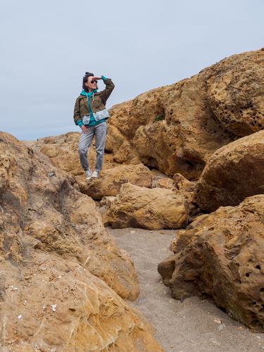 Woman looking into the distance while standing on rocks Woman looking into the distance while standing on rocks