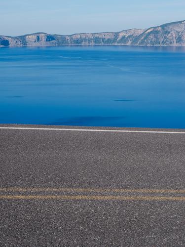 Дорожное полотно и голубая вода озера