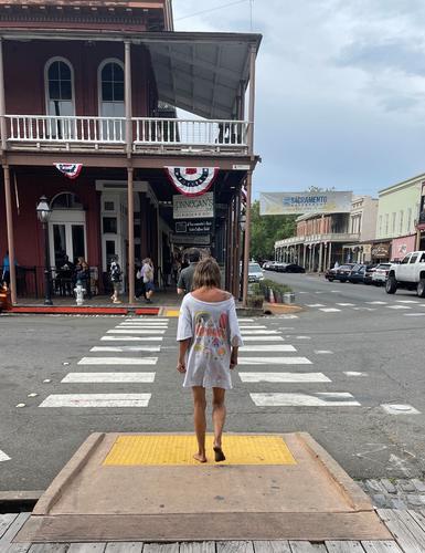 Человек в длинной футболке переходит дорогу Человек в длинной футболке переходит дорогу