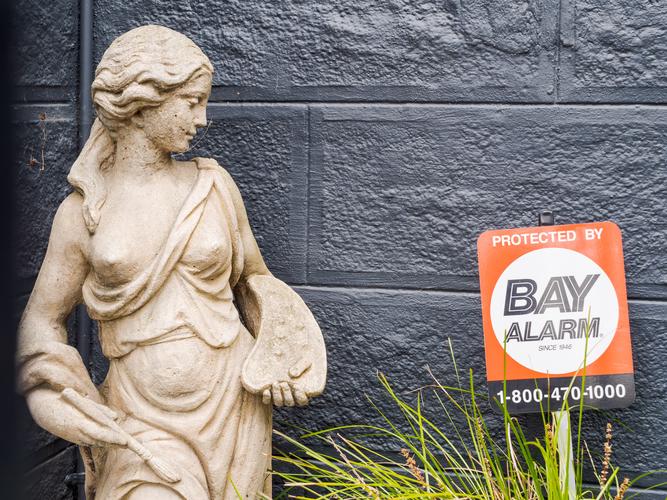 Статуя рядом с надписью Protected by Bay Alarm