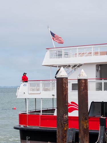 Женщина в красной футболке и американский флаг на корме судна